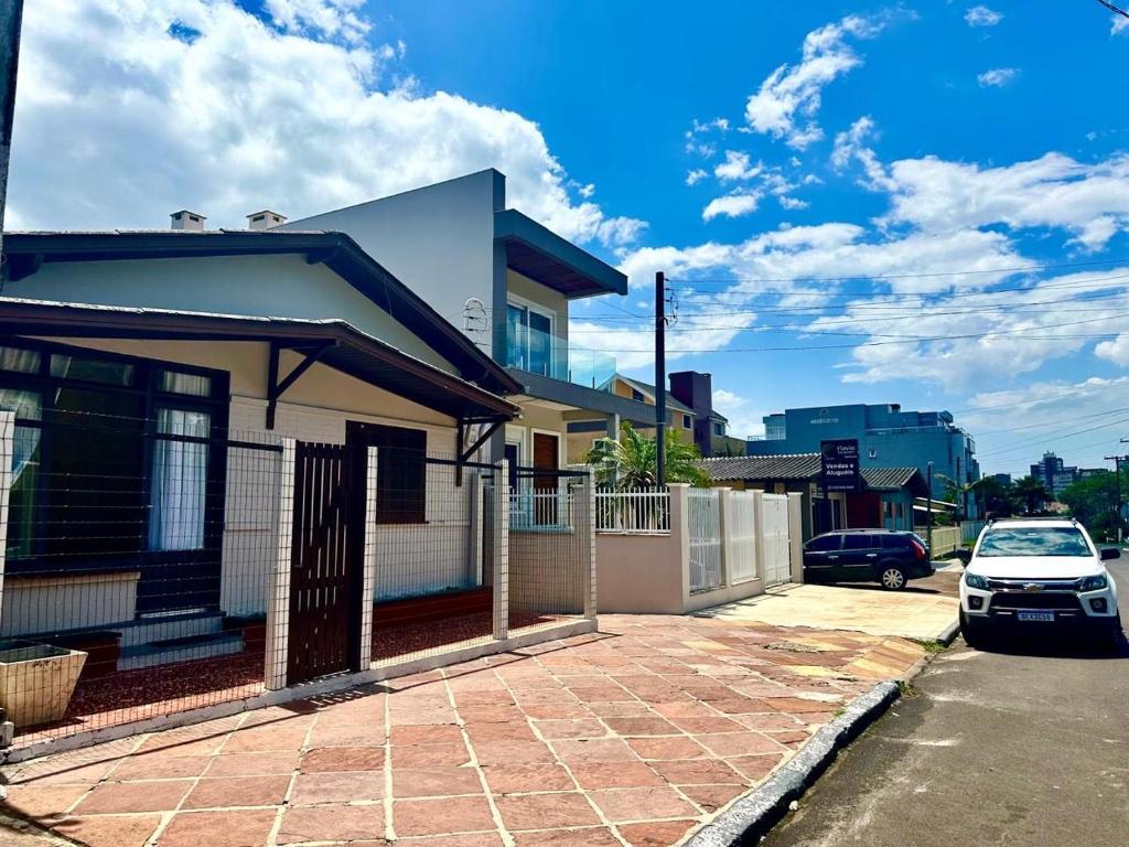 une voiture blanche garée devant une maison dans l'établissement Villa Ruth, a casa que voce vai amar, à Torres