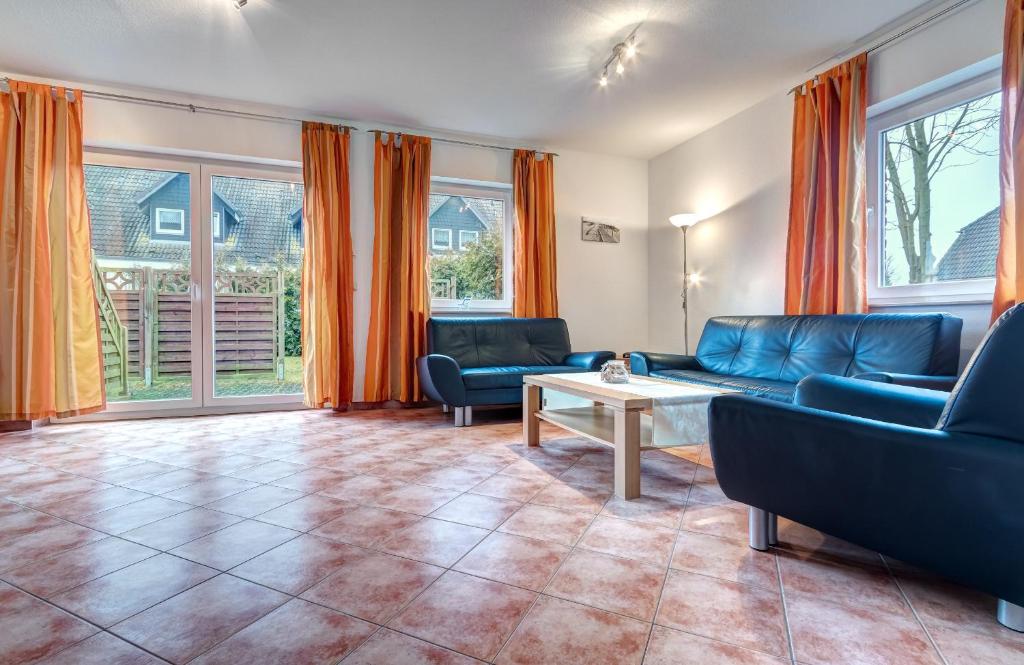 a living room with couches and a table and windows at Ferienhaus "Seestern" in Karlshagen