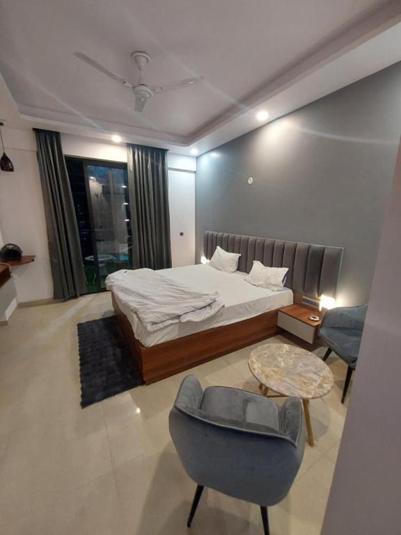 a bedroom with a bed and a chair and a table at 1001 new hazratganj in Nilmatha