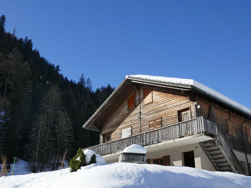 a log cabin with a balcony in the snow at Apartment Prou Forestside by Interhome in Campo Blenio