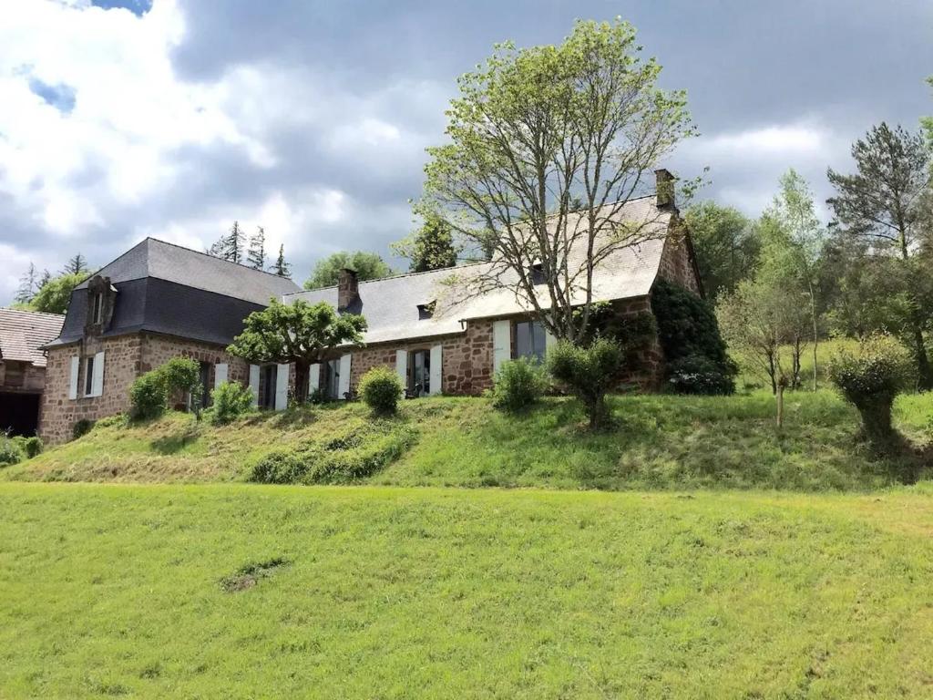 une maison sur une colline avec une pelouse dans l'établissement Maison accueillante avec vue sur le jardin à Villac, à Villac