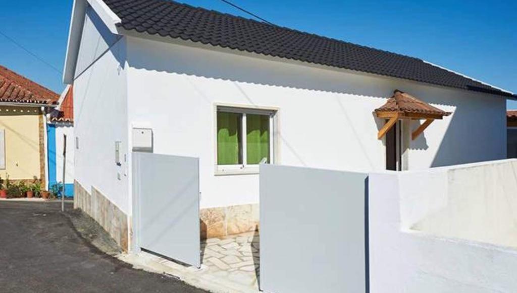 a white house with a fence in front of it at Ericeira Dream Stay in Ericeira