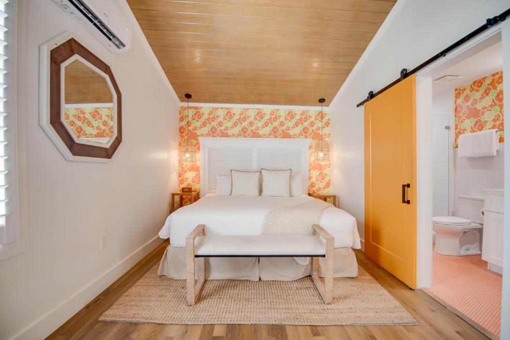 een slaapkamer met een wit bed en een badkamer bij Citrus Queen at Custom House Inn in Key West