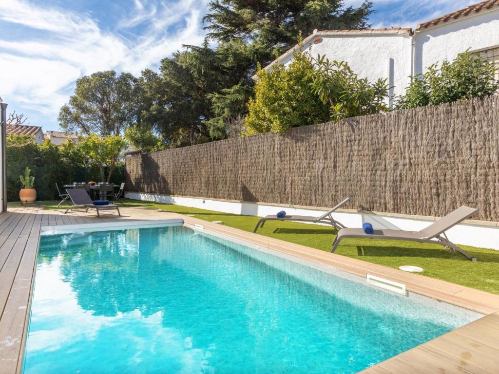 een zwembad met twee stoelen en een hek bij Holiday Home La Manzaneta by Interhome in Calonge
