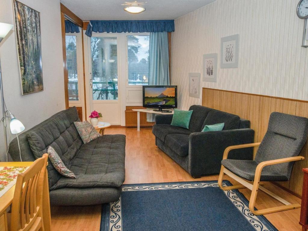 ein Wohnzimmer mit zwei Sofas und einem Fernseher in der Unterkunft Holiday Home Kylpylä-hotelli- room 442 by Interhome in Ikaalinen