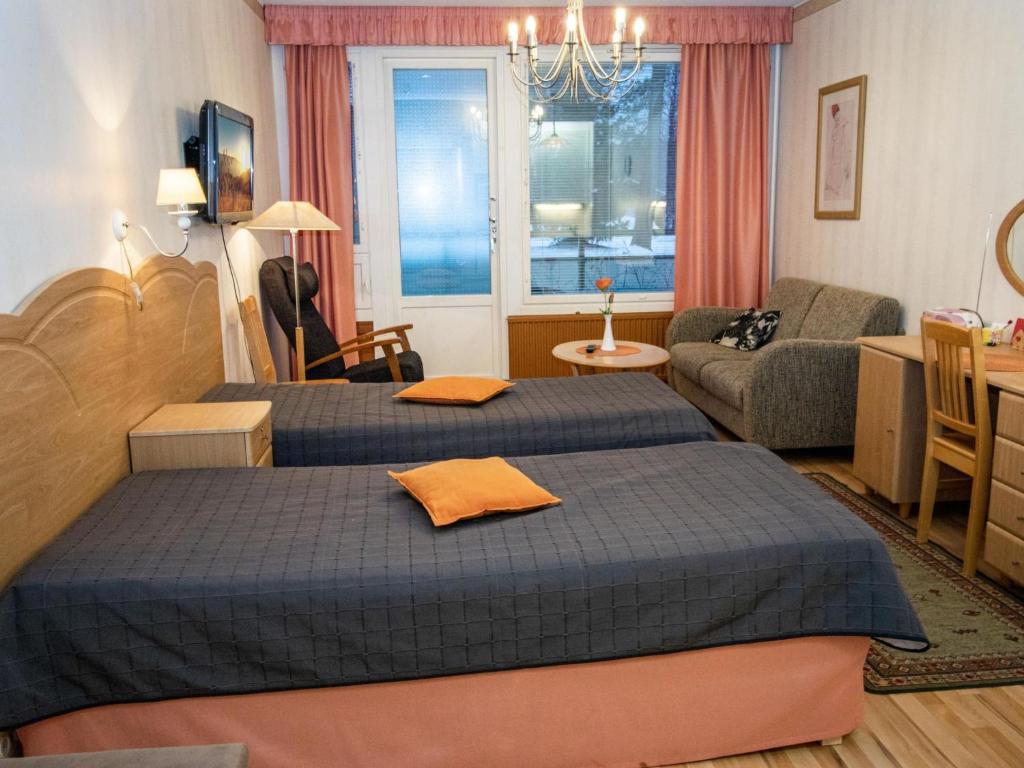 ein Hotelzimmer mit zwei Betten und einem Wohnzimmer in der Unterkunft Holiday Home Kylpylä-hotelli- room 145 by Interhome in Ikaalinen