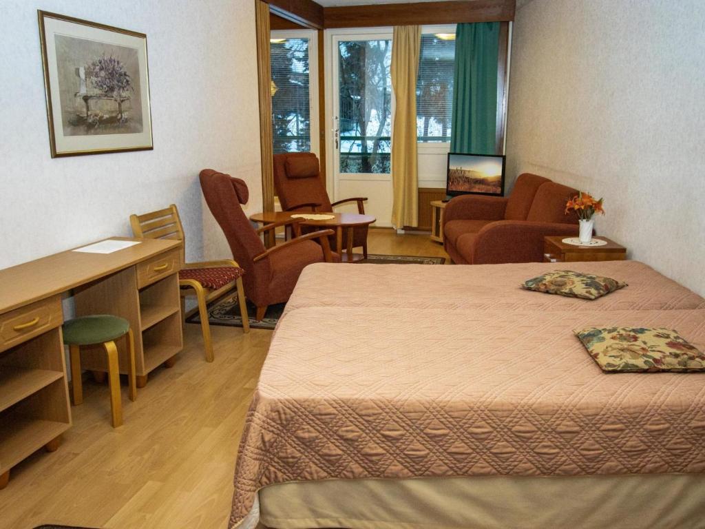 ein Hotelzimmer mit 2 Betten, einem Schreibtisch und Stühlen in der Unterkunft Holiday Home Kylpylä-hotelli- room 242 by Interhome in Ikaalinen