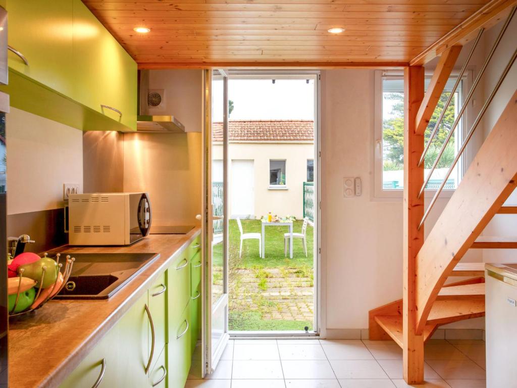 eine Küche mit grünen Schränken und einer Glasschiebetür in der Unterkunft Holiday Home Ker Zelia by Interhome in La Bernerie-en-Retz