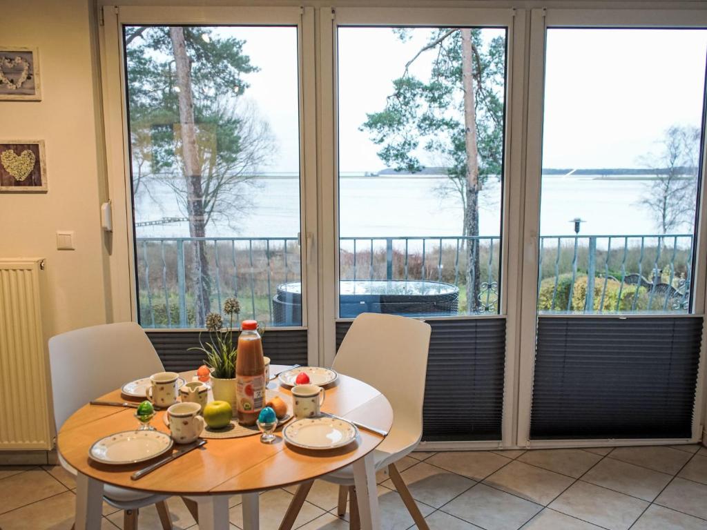 a dining room with a table and views of the water at Apartment Müritz Ferienpark Röbel-55 by Interhome in Röbel