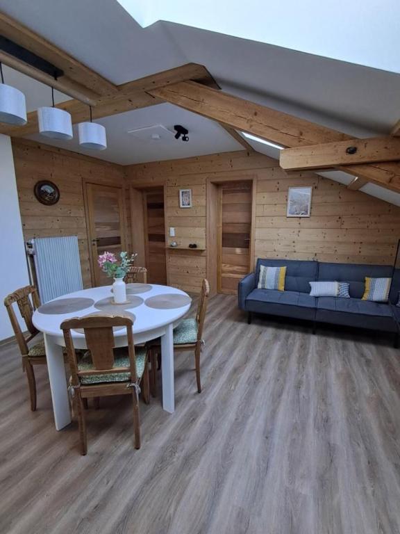 un salon avec une table, des chaises et un canapé dans l'établissement Gîte 5 personnes, à Le Bonhomme