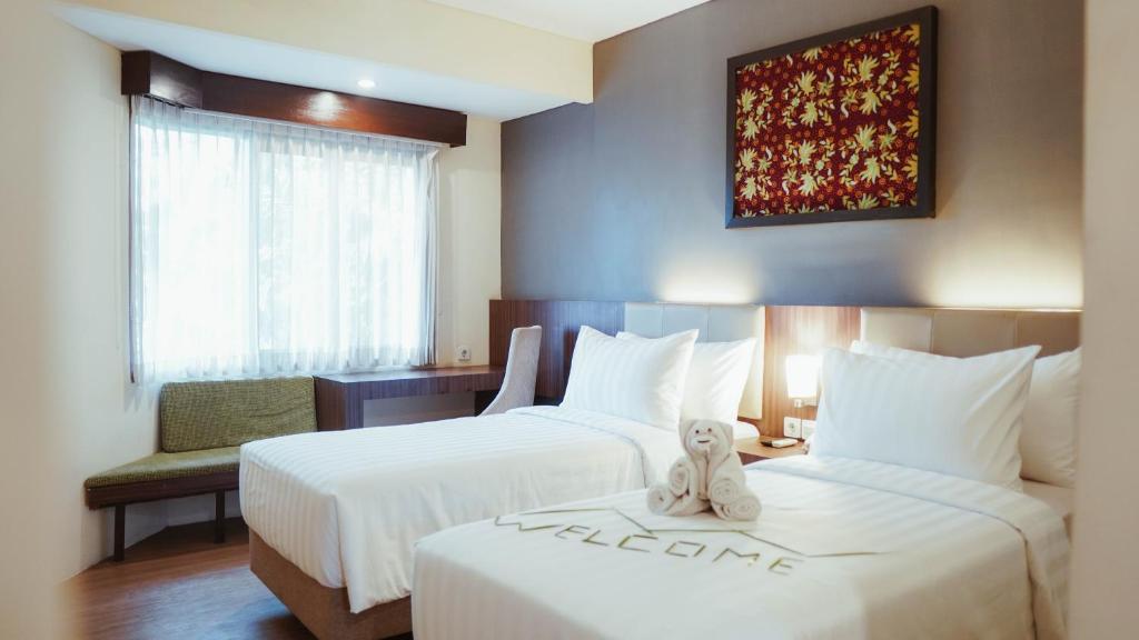 Postel nebo postele na pokoji v ubytování Tuwuh Hotel at Kayutangan