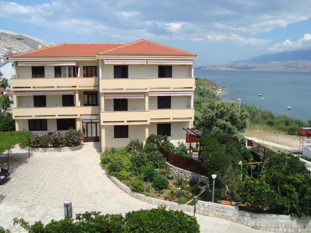 un edificio de apartamentos con vistas al agua en Rooms Villa Andreja, en Pag