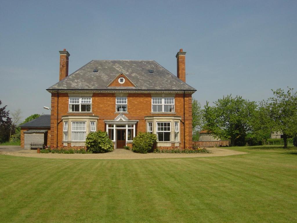 una gran casa de ladrillo con un gran patio de césped en Furtho Manor Farm, en Milton Keynes