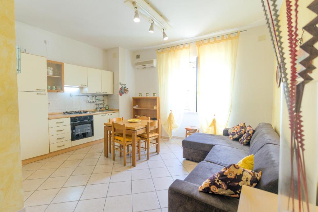 un soggiorno con un divano blu e una cucina di Appartamenti Vacanze Roberta a San Vincenzo