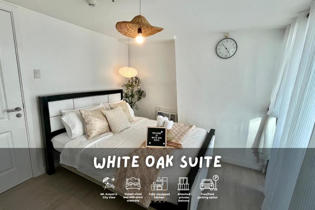 Un dormitorio con una cama con un reloj en la pared. en Suite - Entire 1BR with Huge Balcony & Mt Arayat View, en San Fernando