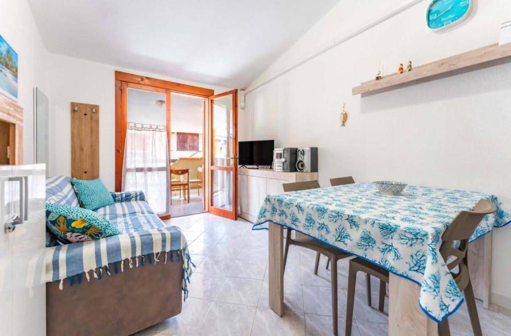 una sala da pranzo con un tavolo e un divano di Casa Vale a Villasimius