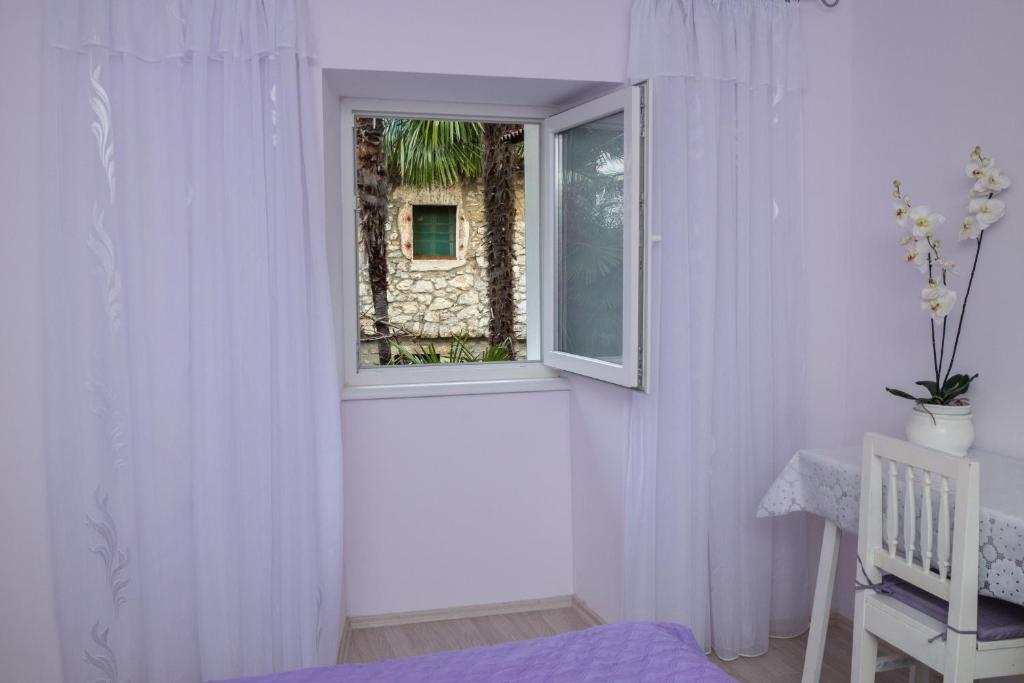 biały pokój z oknem i łóżkiem w obiekcie Apartman Đurđica w mieście Lovran