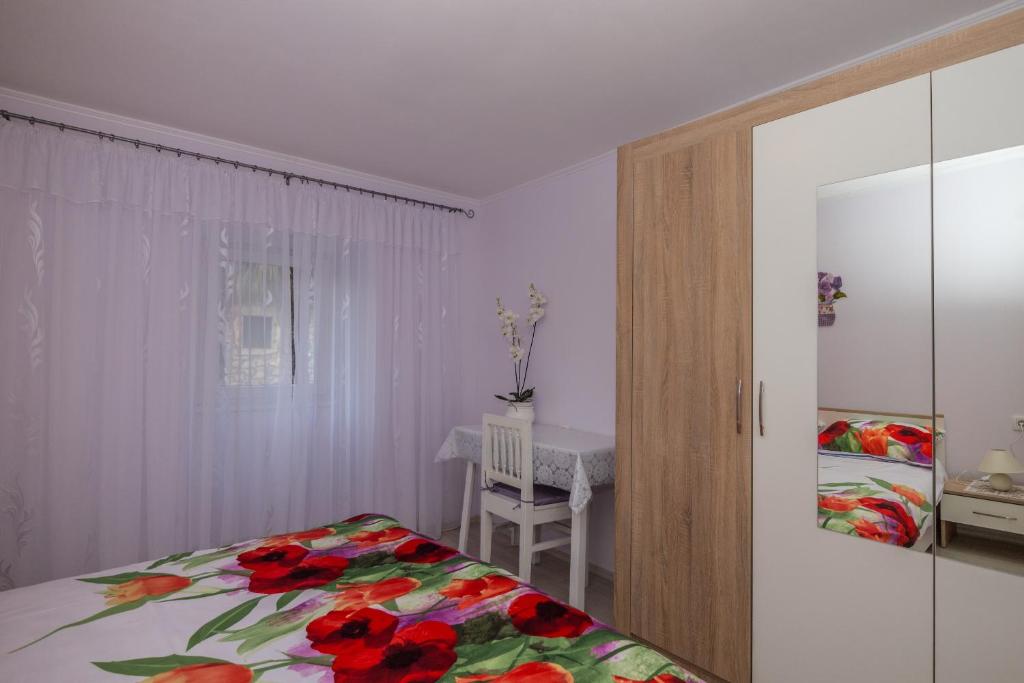 sypialnia z łóżkiem i stołem z krzesłem w obiekcie Apartman Đurđica w mieście Lovran