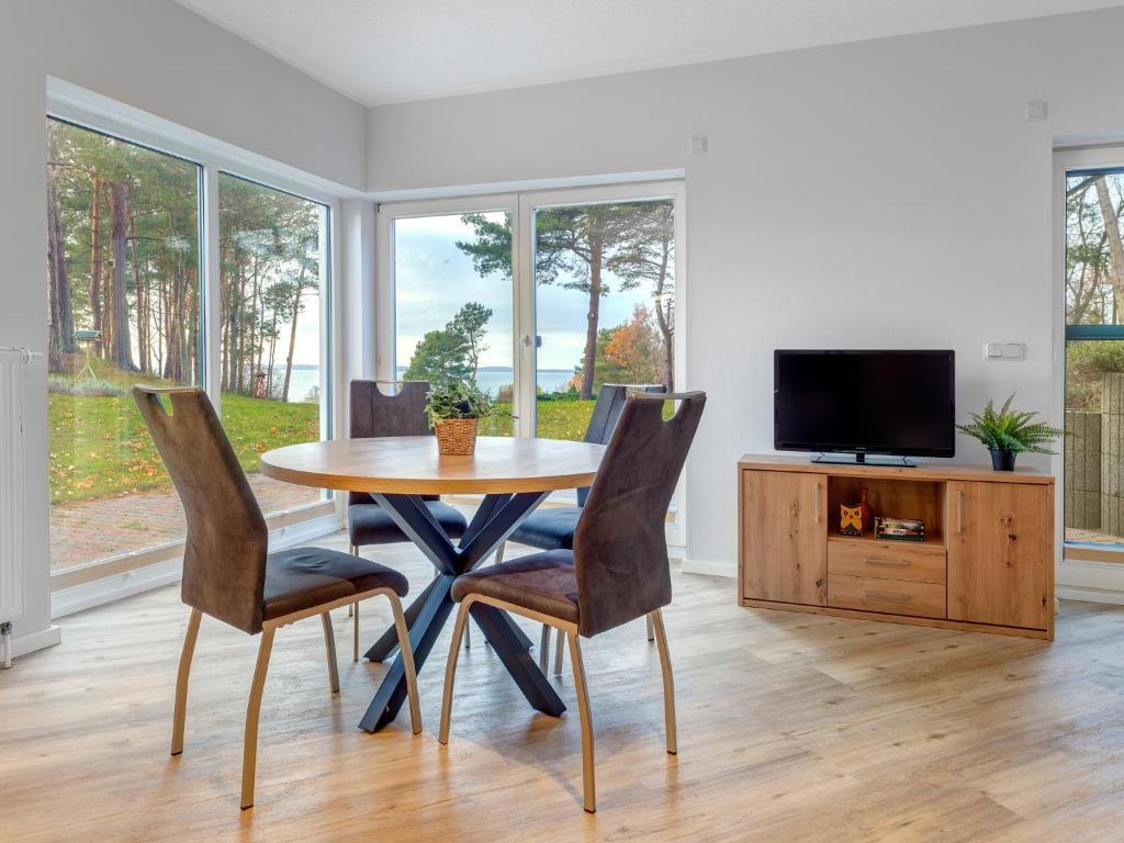 a dining room with a table and chairs and a tv at Haus Berlin, Wohnung 2 in Loddin