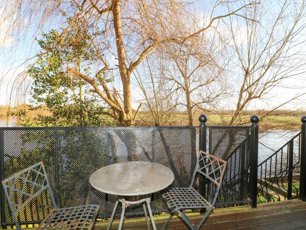 a table and two chairs sitting on a porch at River Cottage in Derby