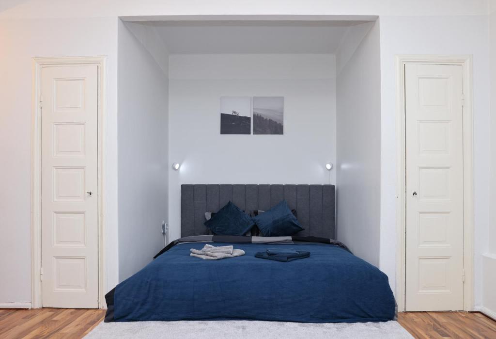 una camera da letto con un letto blu con due porte bianche di Spacious Cozy Corner a Helsinki