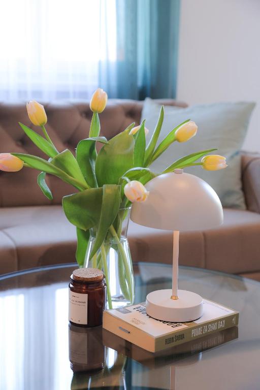 a vase with flowers in it on a table at Apartman Mint&White Borik in Banja Luka