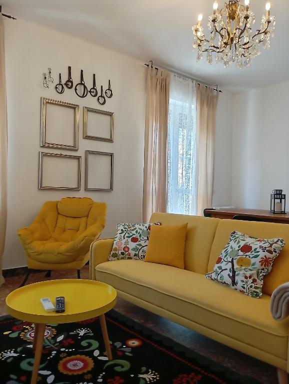a living room with a yellow couch and a table at Ca 'Romanel in Garda