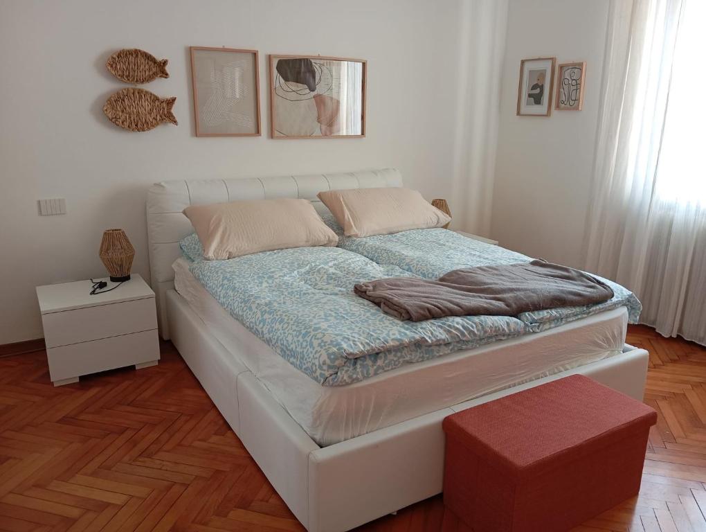 a white bed in a room with a table at Ca 'Romanel in Garda