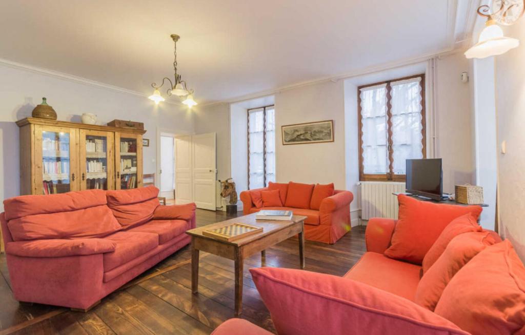 Il comprend un salon doté d'un mobilier orange et d'une télévision. dans l'établissement La Magnanerie, à La Chapelle-Blanche