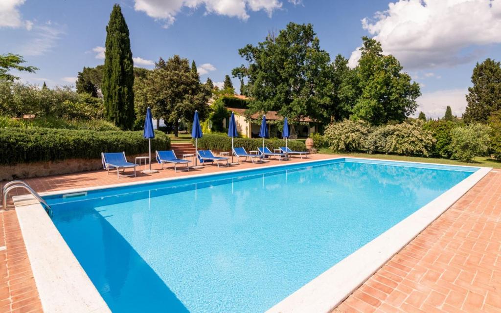 a pool with chairs and umbrellas next to a house at Agriturismo La Godiola in Gioiella