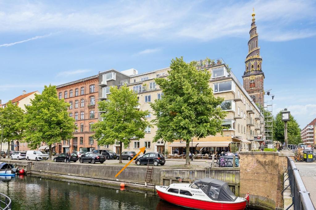 a boat is docked in a canal in a city at CanalLiving-CPH in Copenhagen