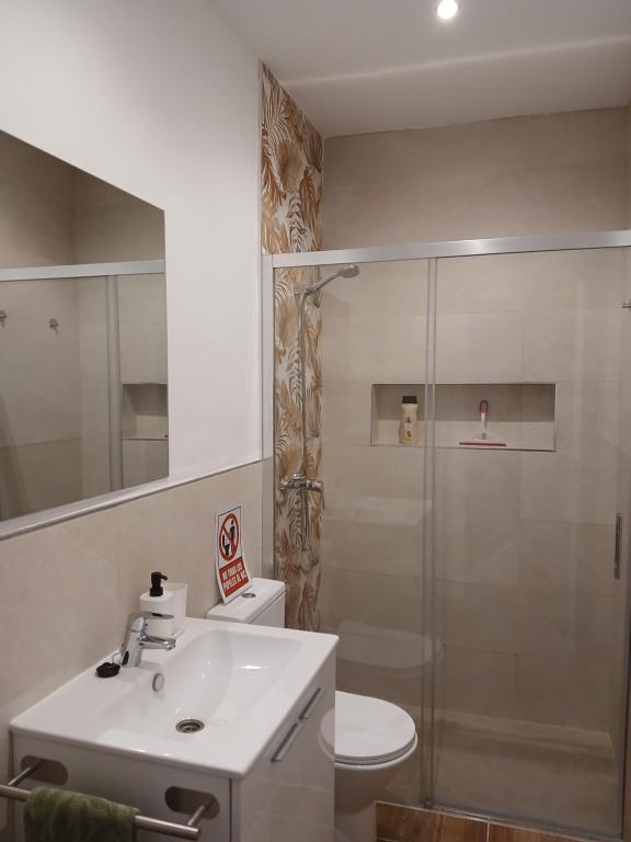Un baño con inodoro, lavabo y ducha. en Residencial Golf jerez, en Jerez de la Frontera