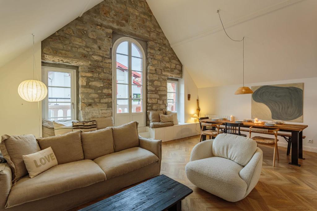 a living room with a couch and a dining room at Appartement Mer et Pierres - Welkeys in Saint-Jean-de-Luz