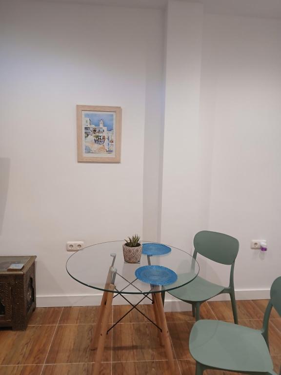 comedor con mesa de cristal y sillas en Residencial Golf jerez, en Jerez de la Frontera