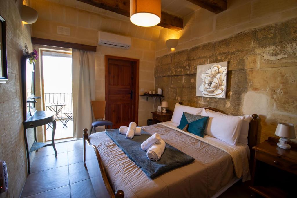 a bedroom with a bed with two pillows on it at Il figolla b&b in Xagħra