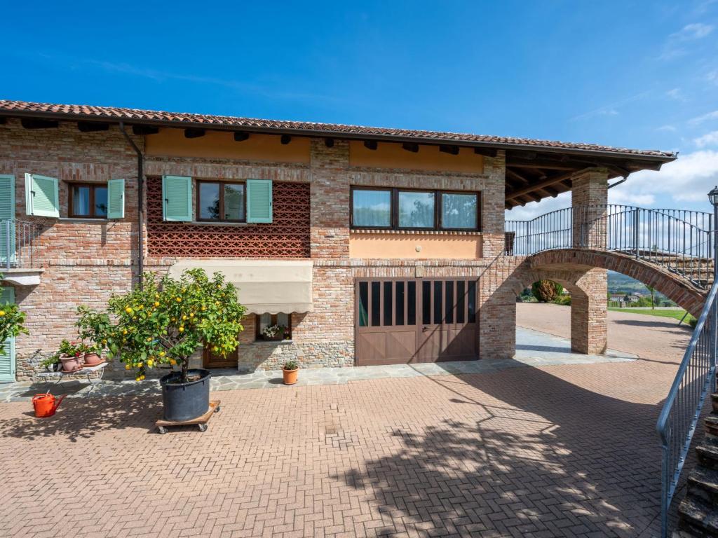 a brick house with a gate and a driveway at Holiday Home Antica Cascina by Interhome in Castagnole Lanze