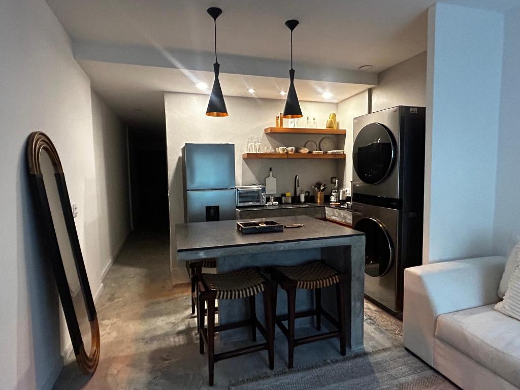 a small kitchen with a table and a refrigerator at Apartamento nuevo en zona romántica a 3 cuadras de la playa in Puerto Vallarta