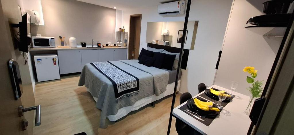 a small bedroom with a bed and a kitchen at Bauten Cabo Branco 310 in João Pessoa