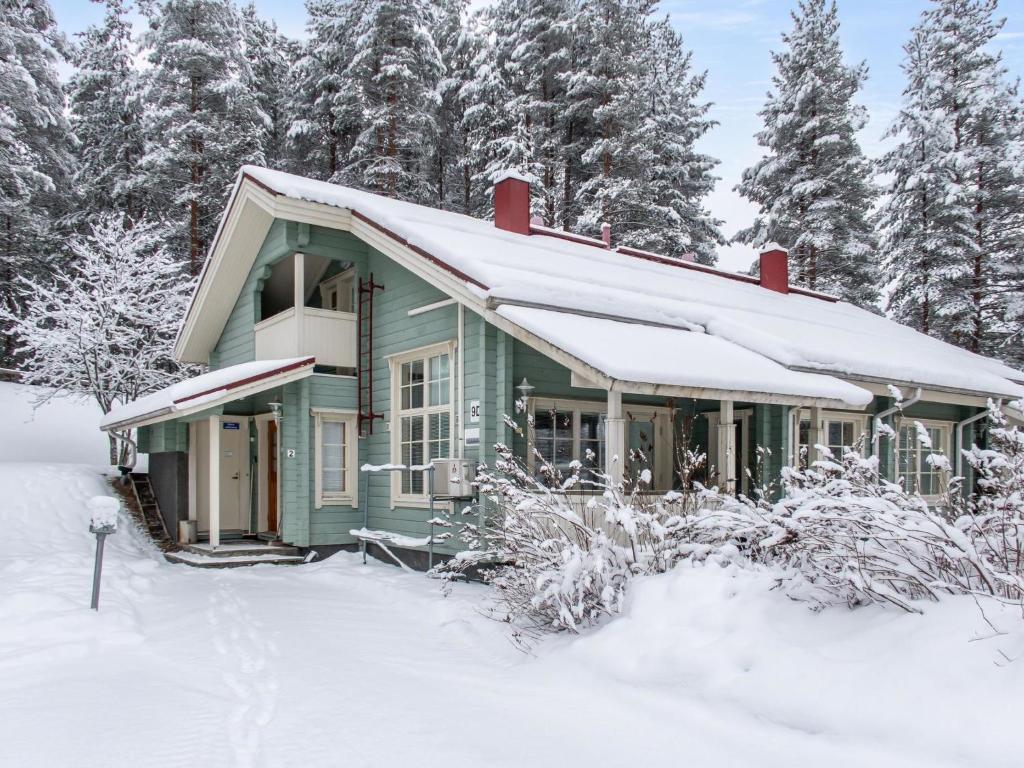 a green house covered in snow with trees at Holiday Home Katinkulma 2 by Interhome in Vuokatti