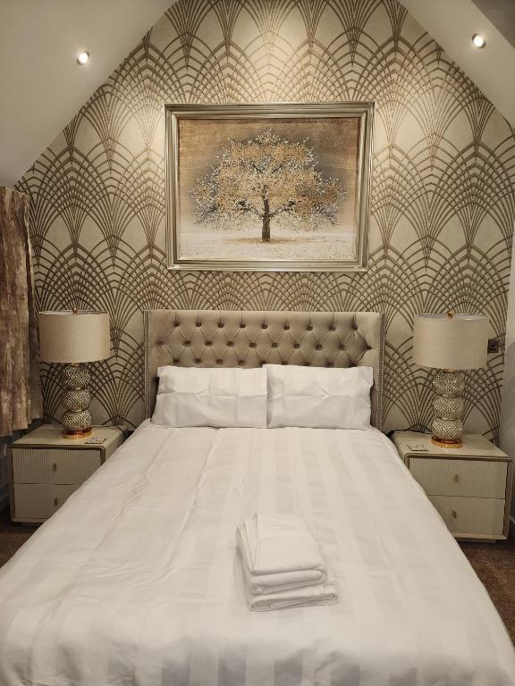 a bedroom with a large white bed with two lamps at CITY CENTRE LUXURY House WITH THREE VERY LARGE SIZE BEDROOMS in Belfast
