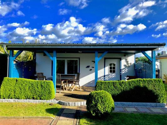 a house with a blue roof and a patio at Lenis Strandhaus in Loissin