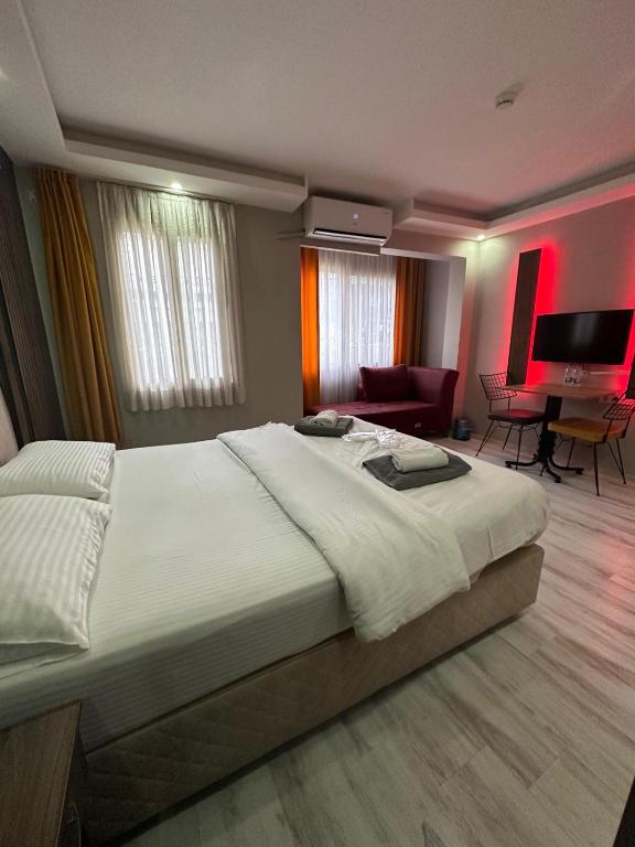 a bedroom with a large bed and a living room at Vero Hotel in Konak