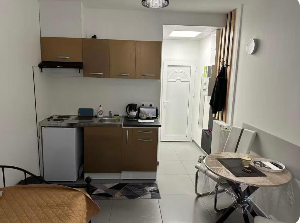 - une petite cuisine avec une table et une petite table dans l'établissement Studio TenStar, à Aubervilliers
