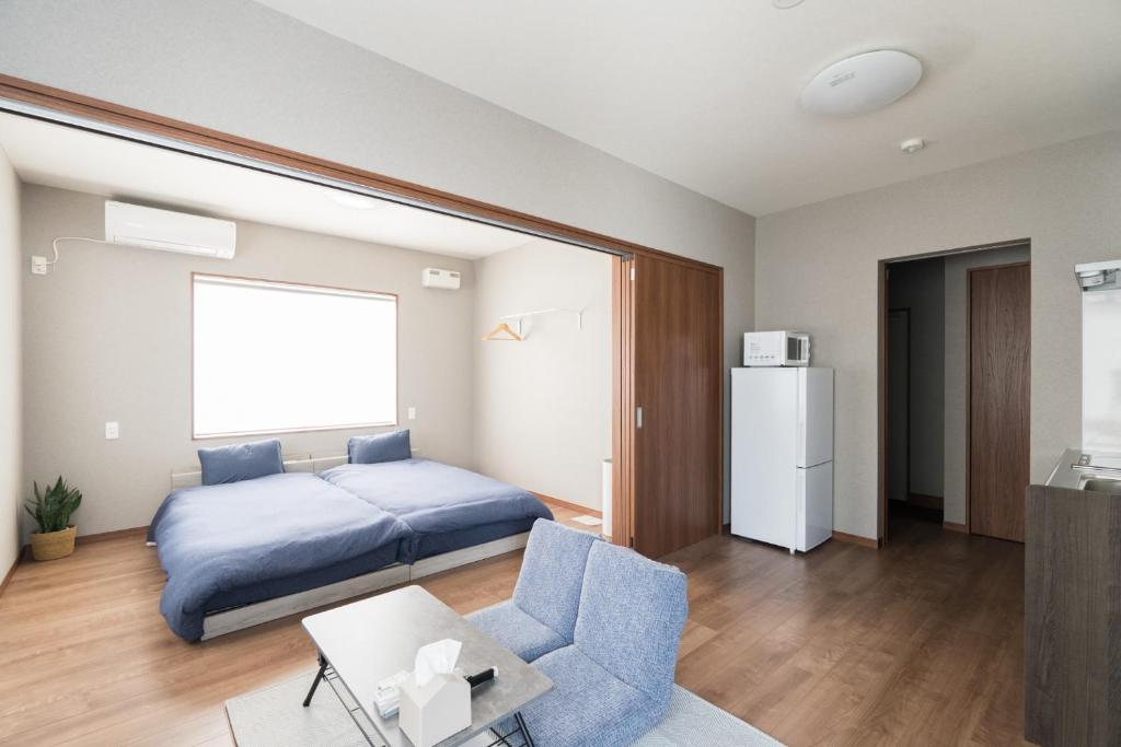 a bedroom with a bed and a couch and a table at HOTEL PG -2- - Vacation STAY 38335v in Onomichi