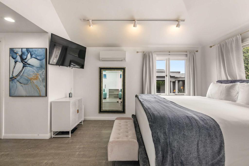 a bedroom with a large bed and a mirror at Chic La Jolla Studio Steps to Ocean & Dining in San Diego