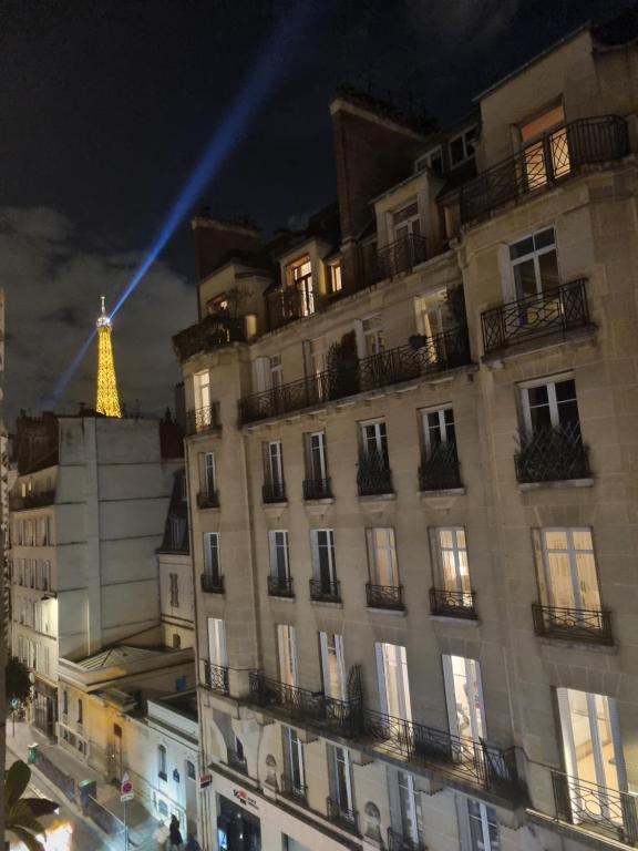 un bâtiment avec la tour eiffel en arrière-plan dans l'établissement Chambre privée - Vue Tour Eiffel, à Paris