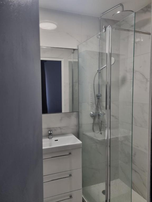 une salle de bain blanche avec un lavabo et une douche dans l'établissement Chambre privée - Vue Tour Eiffel, à Paris