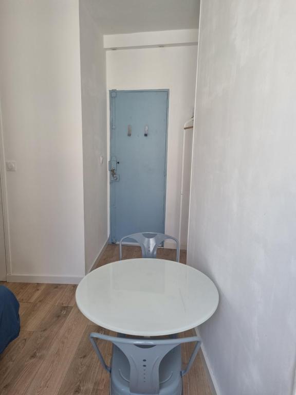 - une table blanche dans une chambre avec porte dans l'établissement Chambre privée - Vue Tour Eiffel, à Paris
