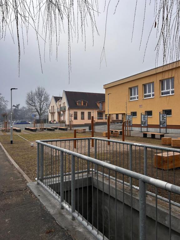 a fence in front of a park with buildings at Penzion Bilina in Teplice