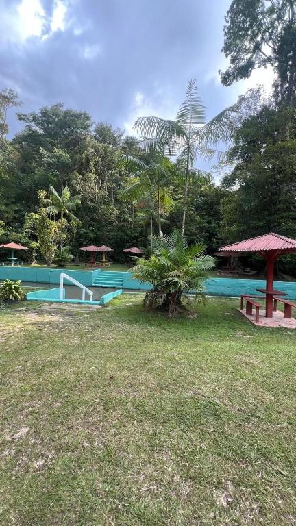 a resort with a pool and a picnic table and trees at Paraíso in Benfica
